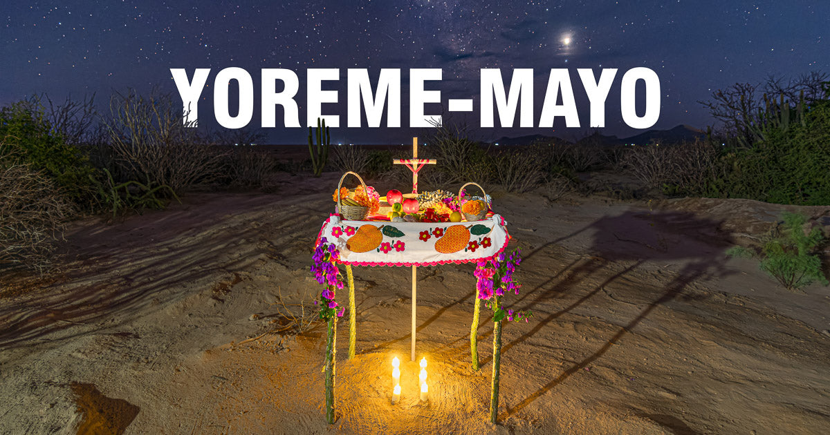 Altar yoreme-mayo iluminado con velas en el desierto bajo un cielo estrellado.