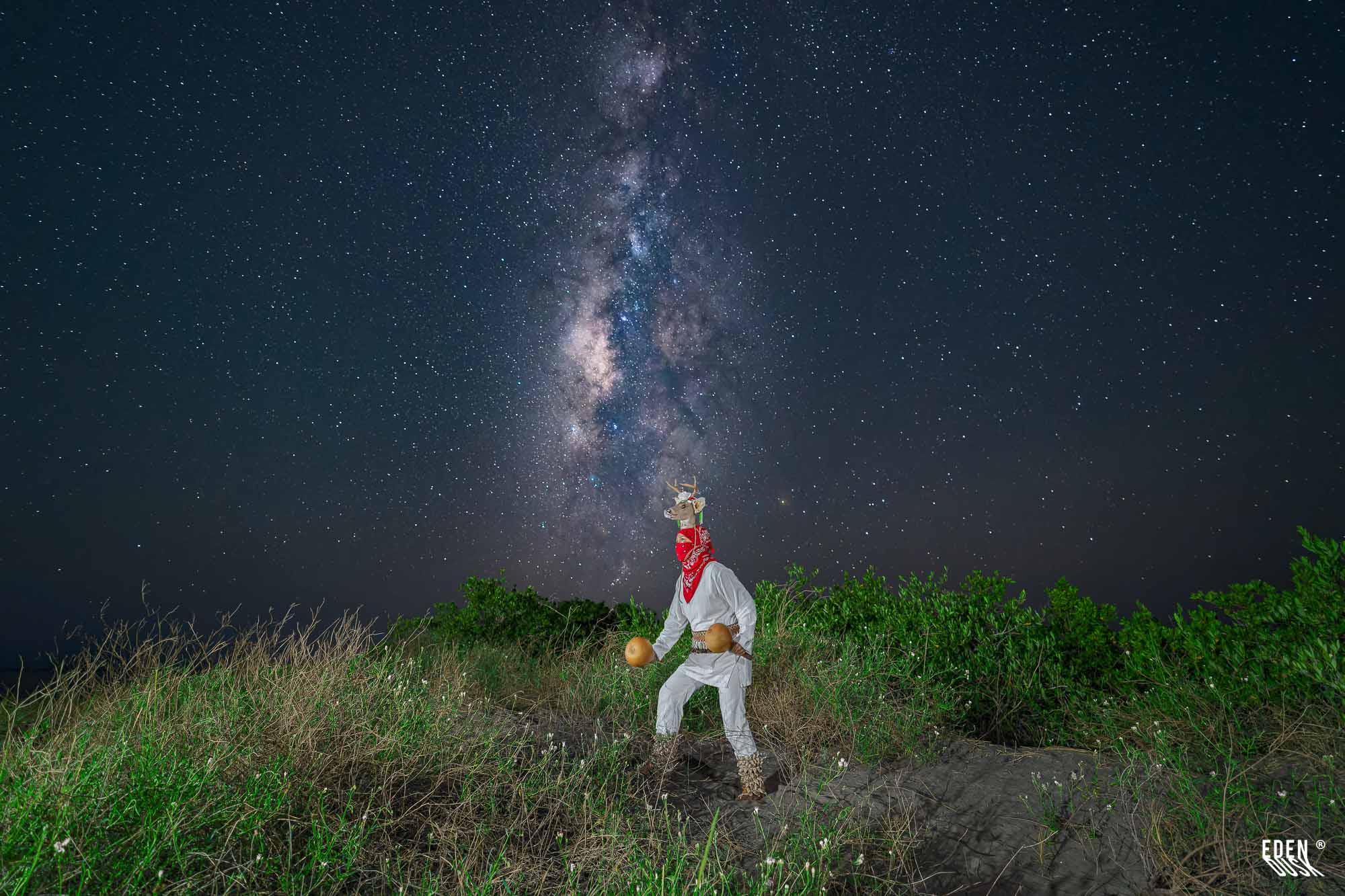 Figura del Venado bajo la Vía Láctea, ladera con vegetación.