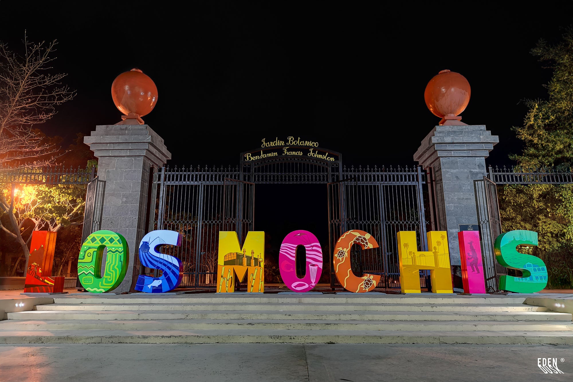 La arquitectura del portón principal del Parque Sinaloa, iluminada majestuosamente contra la oscuridad de la noche.