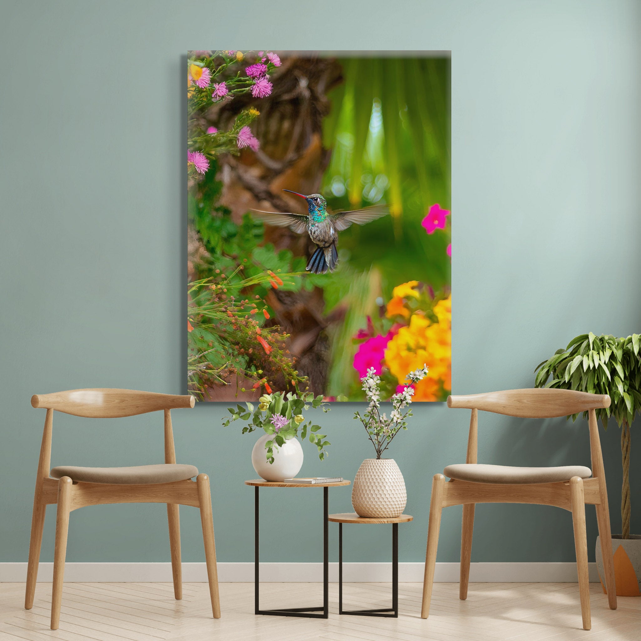 Canvas en interior; colibrí suspendido entre flores de colores y fondo verde suave; sensación de ligereza y foco nítido en un entorno natural.