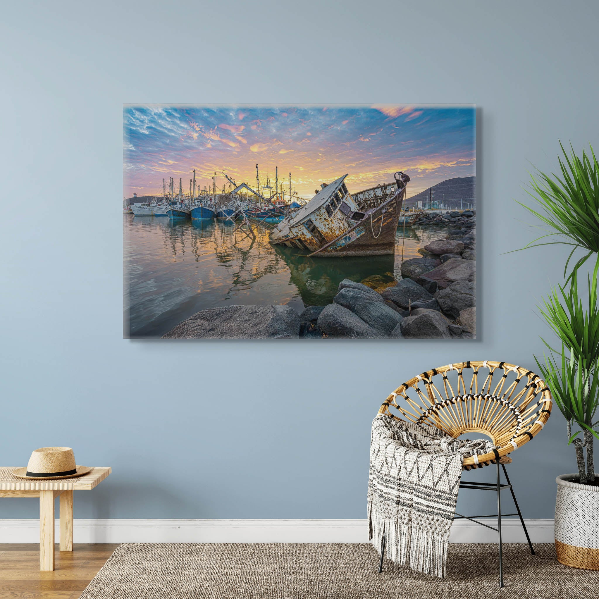 Canvas colgado en interior neutro; embarcación encallada al amanecer con cielo suave y reflejos dorados; atmósfera serena y equilibrada.
