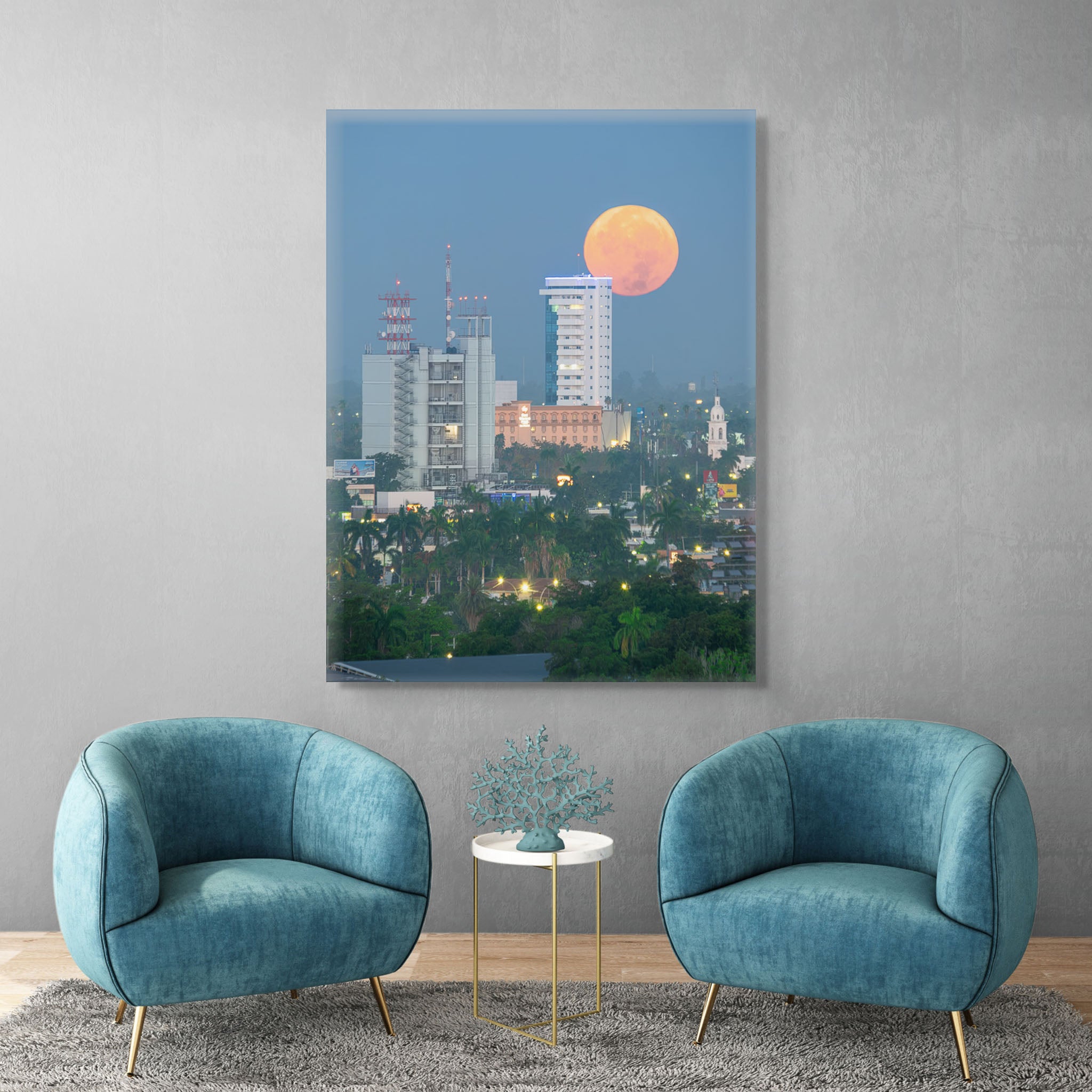 Canvas en interior sobrio; superluna cálida descendiendo en cielo azul sobre silueta urbana con torres y palmeras; atmósfera serena y equilibrio visual.