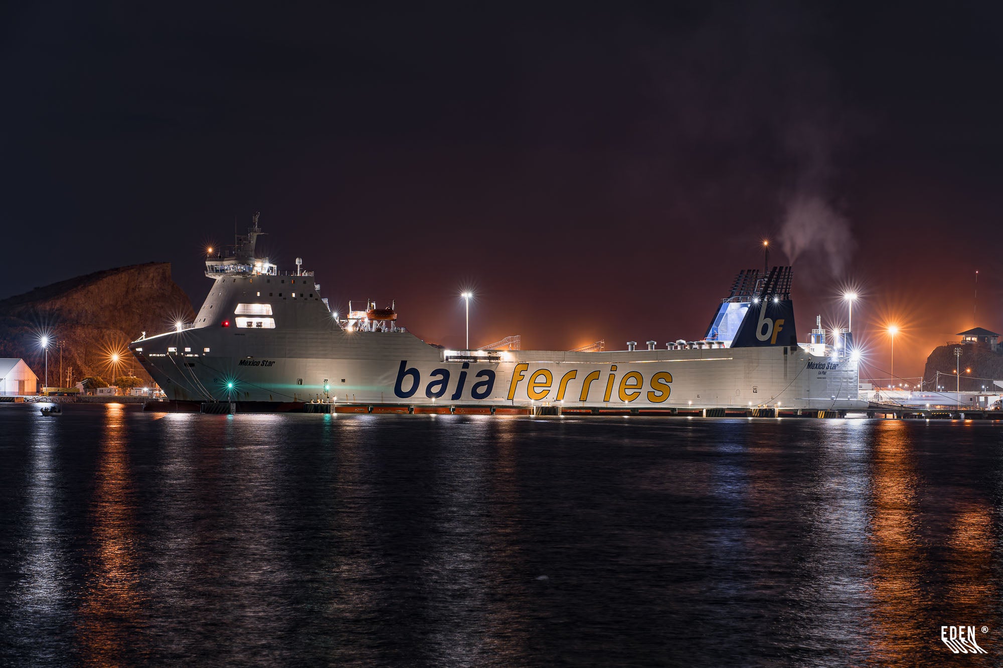 Buque de Baja Ferries “México Star” atracado en el puerto de Topolobampo de noche, con luces del muelle y reflejos sobre el agua, Sinaloa.