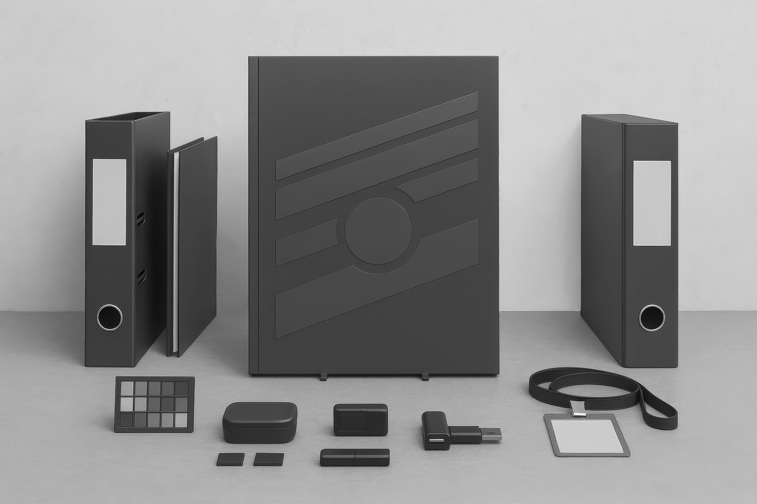 Carpetas y contenedores negros para archivo junto a memorias USB, tarjetas y gafete; cuaderno central con relieve geométrico sobre superficie gris.
