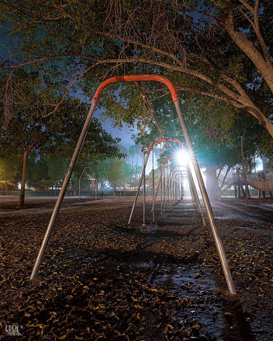 Perspectiva vertical de una estructura de juegos infantiles en el Parque Sinaloa, destacando su forma solitaria bajo la luz artificial de la noche.
